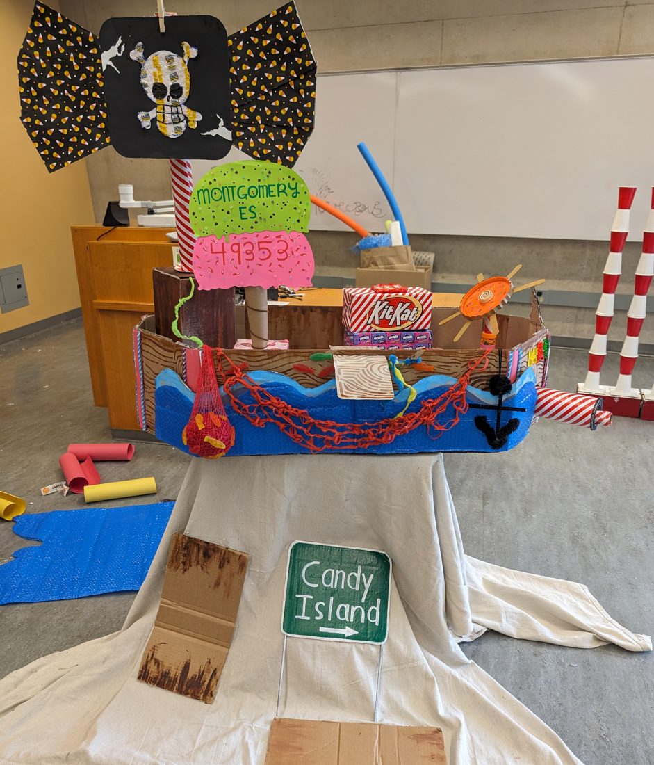 A cardboard pirate ship built entirely at home, complete with a candy stash and a Candy Island sign